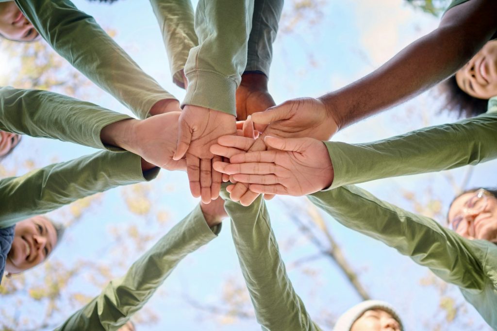 Teamwork, collaboration and low angle of people with hands together for team building. Motivation,